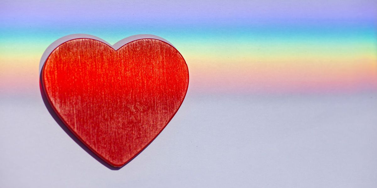 et rødt hjerte med en regnbue som løper gjennom det